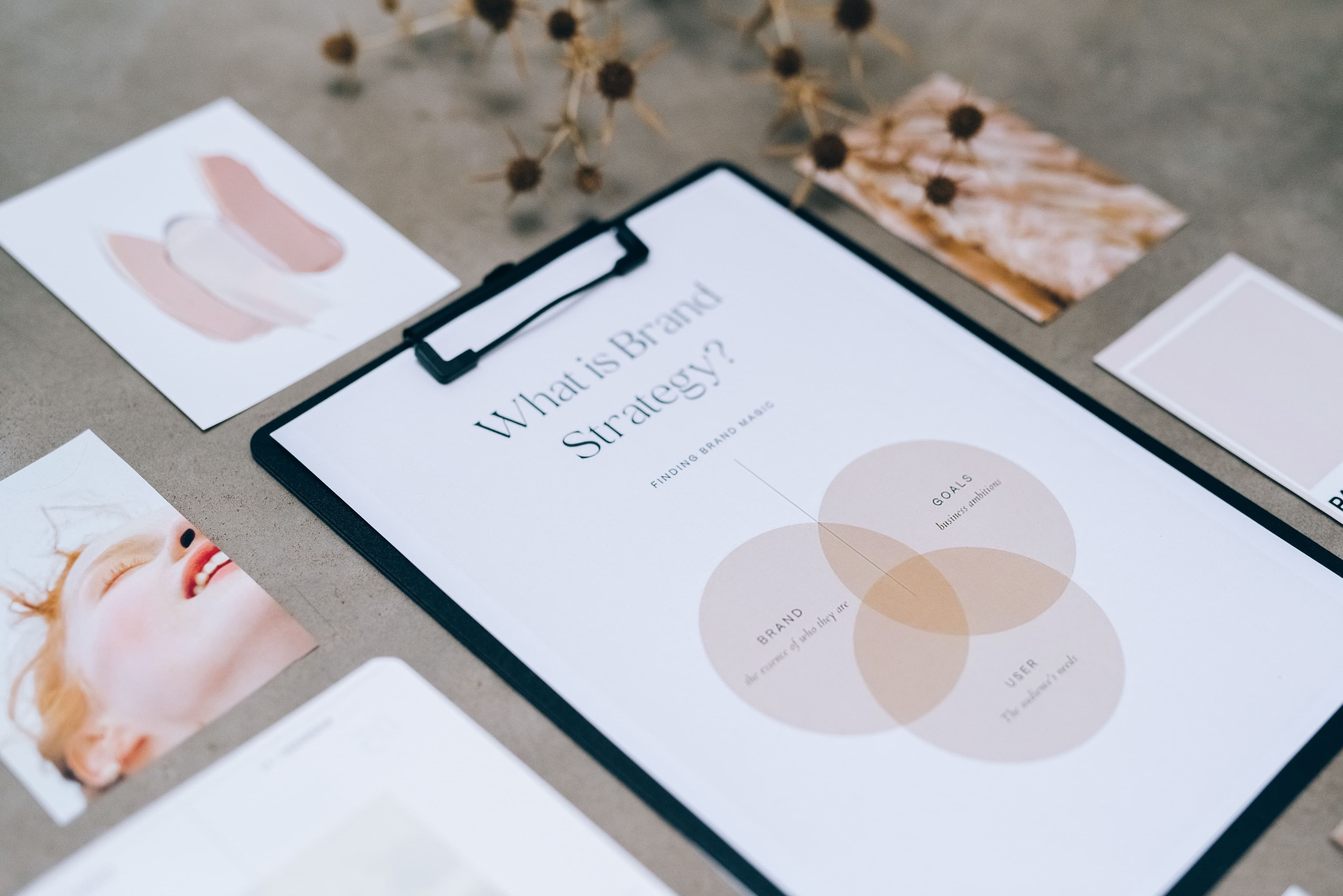 Brand strategy notes, colour references and photography laid out on a desk